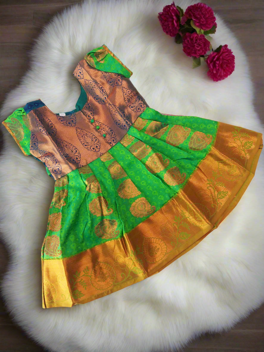 Green and gold pattu silk frock for baby girls with embossed puff sleeves – traditional Indian kids dress