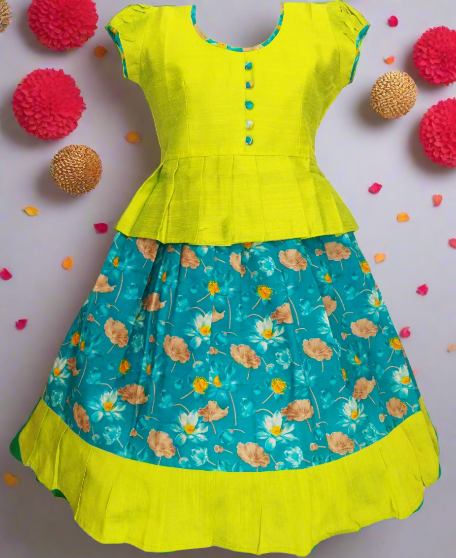 Girls Kalamkari cotton Pattu Pavadai with turquoise floral skirt and lime green ruffle border, paired with a lime green peplum blouse enhanced with Potli buttons.