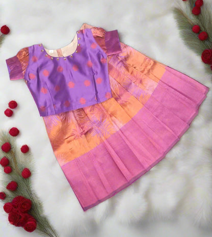 Discover Peach & Purple semi silk Banarasi Pattu lehanga sets for girls at Lotus Ethnic. Featuring Kundan neck work and trendy blouse back design, perfect for festivals & functions.