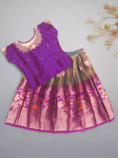 Purple top and patterned skirt set on a gray background