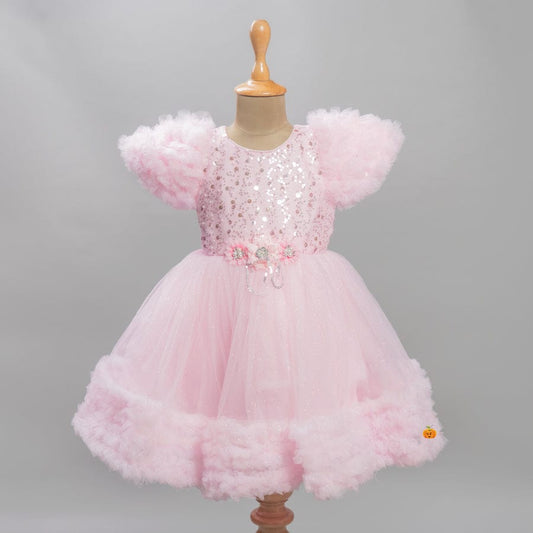 Baby girls pink birthday frock with sequin bodice, puff sleeves, floral belt, and layered net flare – perfect kids party dress.