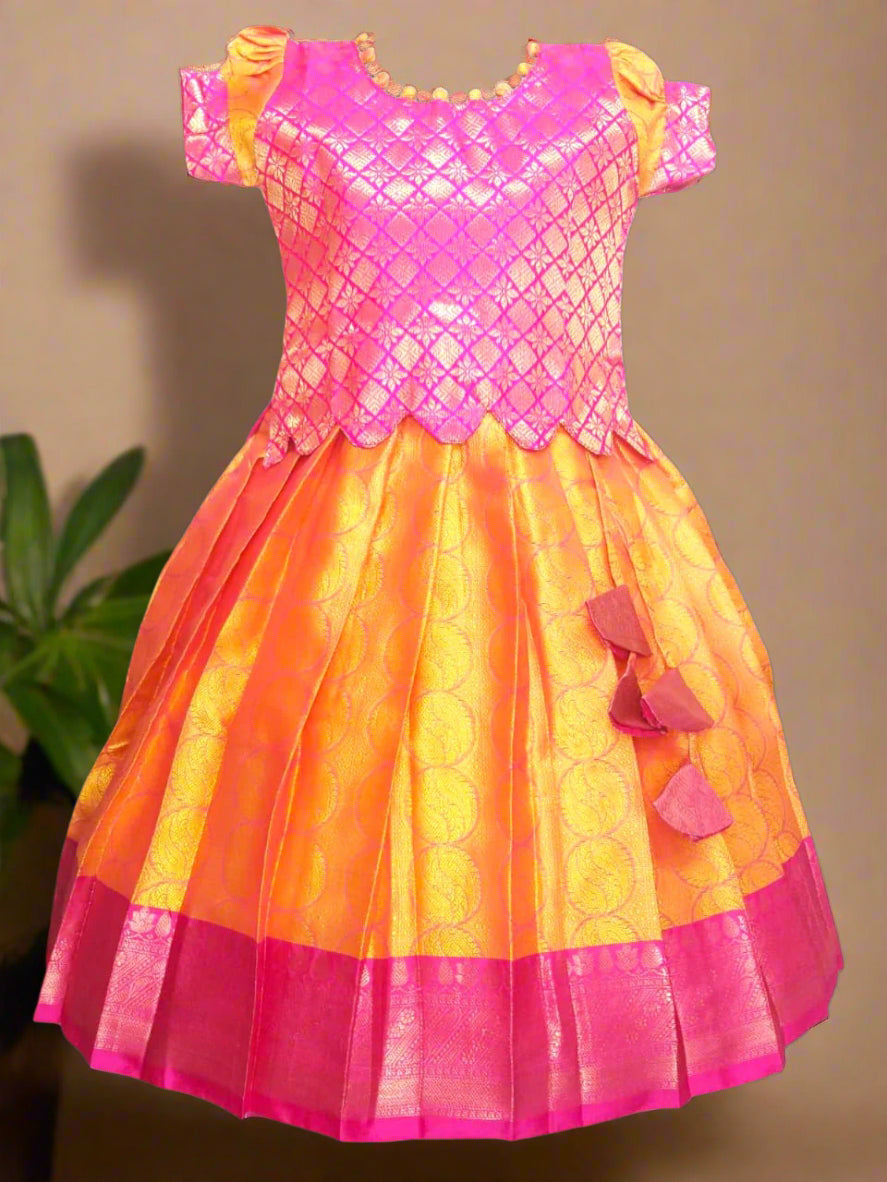 Girls Pink and Yellow Banarasi muslin pattu pavadai with scallop hem top, potli ball neck design, and tassels – ethnic kids festive wear