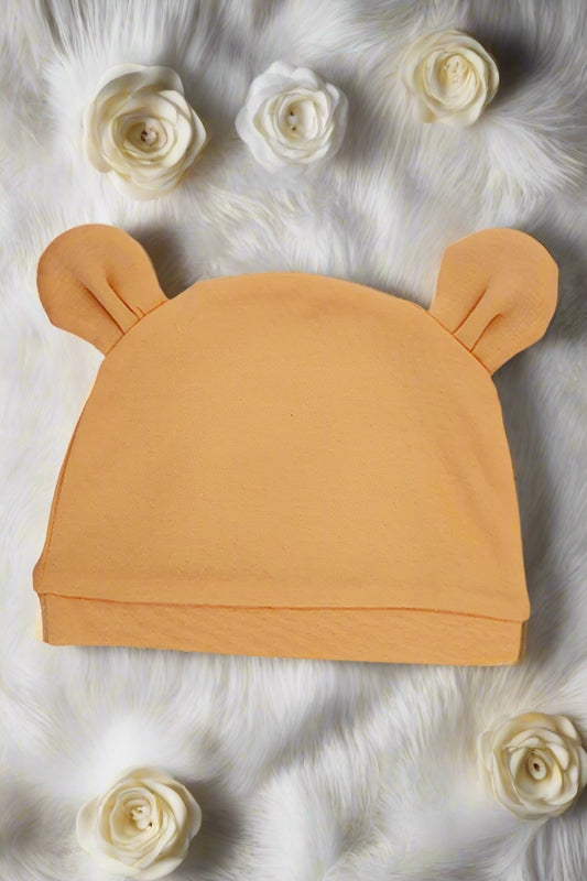 Mustard yellow baby hat with ear designs on a white background