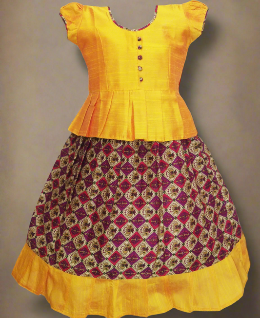 Girls Kalamkari cotton Pattu Pavadai with Maroon floral skirt and Gold ruffle border, paired with a Gold peplum blouse enhanced with Potli buttons