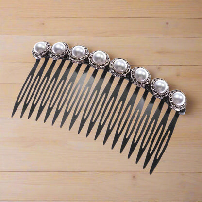 Elegant black plastic hair comb with pearl embellishments in vintage metal casing